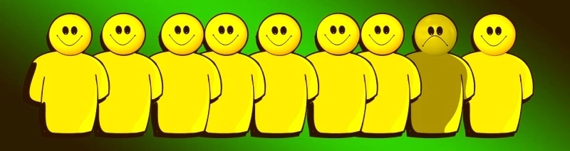 Sieben gelbe Figuren in einer Reihe: Sechs lächeln, während eine in der Mitte ein trauriges Gesicht zeigt und die emotionale Isolation verdeutlicht.