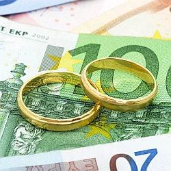 Zwei Eheringe auf Euro‑Scheinen – Hinweis auf Paartherapie als wertvolle Investition in Beziehung und Liebe.