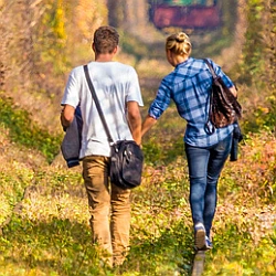 Ein Paar geht Hand in Hand einen gemeinsamen Weg und entwickelt seine Partnerschaft Schritt für Schritt weiter.