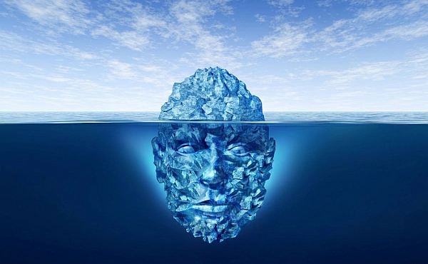 Ein Eisberg in Form eines menschlichen Gesichts verdeutlicht, dass ein großer Teil unseres Erlebens und unserer seelischen Prägungen unter der Oberfläche des Bewusstseins liegt.