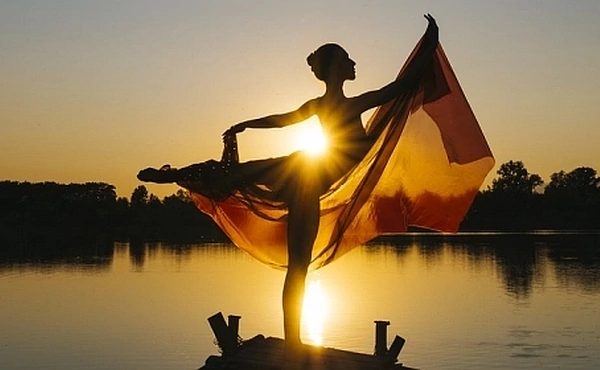 Symbolbild einer Frau, die sich im Licht der aufgehenden Sonne öffnet. Das Bild begleitet den Artikel über Depression und den Weg zu mehr innerer Freiheit über die Reinkarnationstherapie.